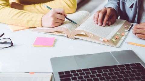 Una persona escribiendo en un libro